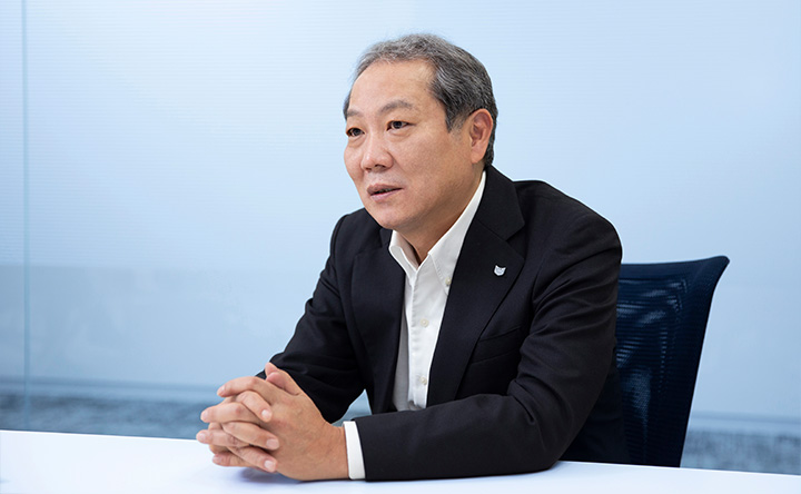 手を組んで語る青山